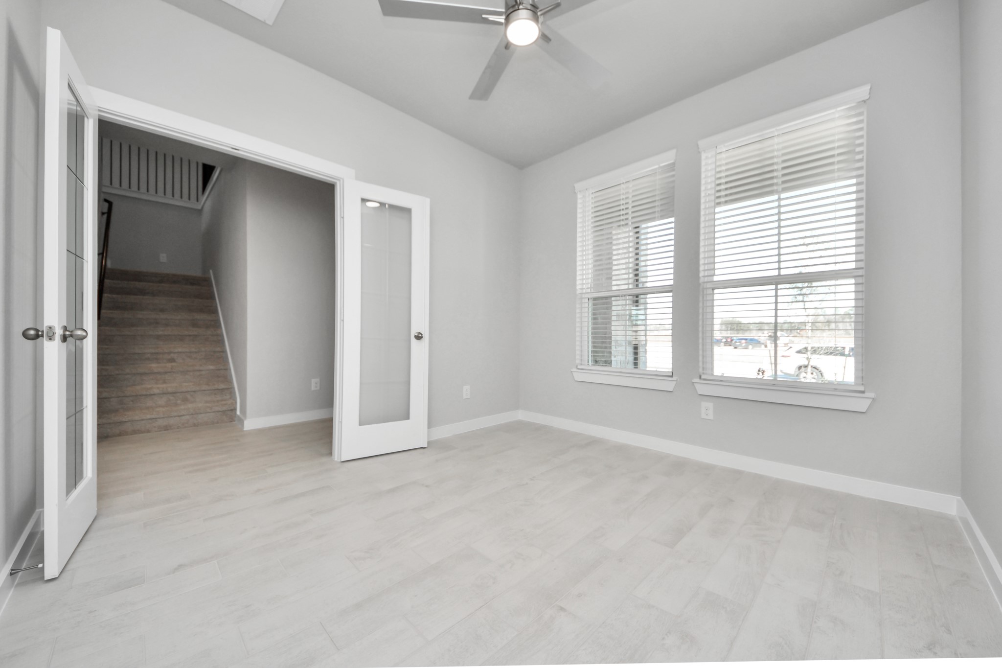 3006 Burris Park Drive Spring, TX 77373 - Photo 6 of 45 Experience the perfect blend of sophistication and warmth in this home office, boasting elegant wood-look tile flooring and flooded with natural light from expansive windows and French doors.