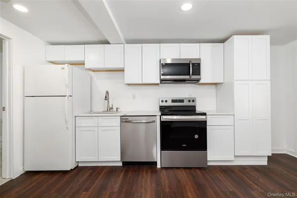 a kitchen with a refrigerator stove and white cabinets