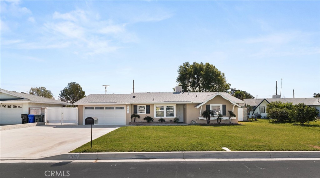 6661 Yucca Avenue Rialto, CA 92376 - Photo 2 of 44 a front view of a house with a yard and garage