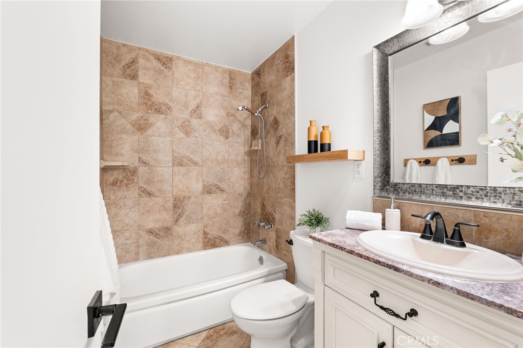 6661 Yucca Avenue Rialto, CA 92376 - Photo 25 of 44 a bathroom with a granite countertop sink a toilet and a bathtub