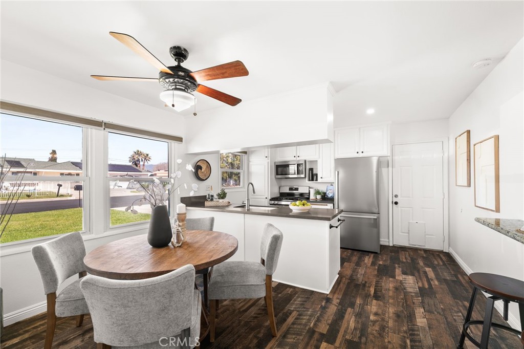 6661 Yucca Avenue Rialto, CA 92376 - Photo 7 of 44 a kitchen with stainless steel appliances kitchen island granite countertop a refrigerator a stove a sink a dining table and chairs with wooden floor