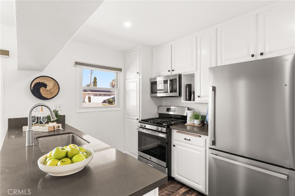 6661 Yucca Avenue Rialto, CA 92376 - Photo 10 of 44 a kitchen with stainless steel appliances a refrigerator a stove a microwave and a sink