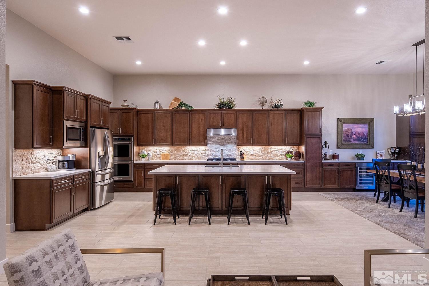 3020 Feathertop Drive Reno, NV 89521 - Photo 13 of 40 a kitchen with stainless steel appliances kitchen island granite countertop a dining table and chairs