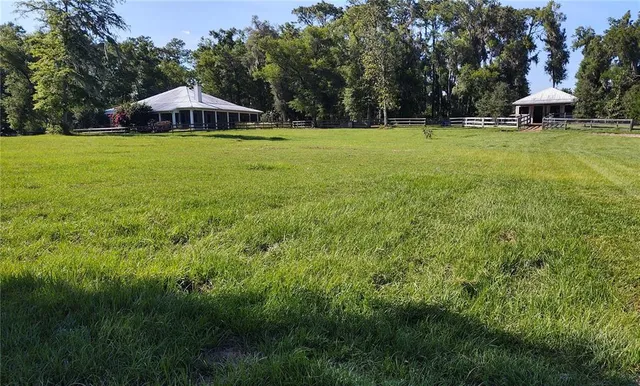 a kitchen with stainless steel appliances kitchen island granite countertop a dining table chairs stove refrigerator and cabinets