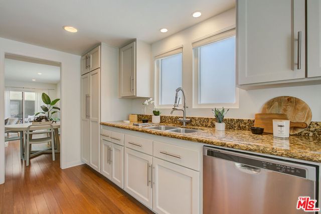 a kitchen with stainless steel appliances granite countertop a sink stove and cabinets