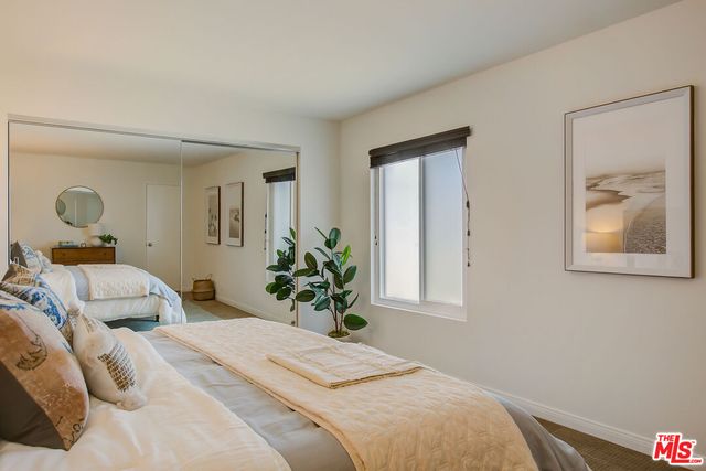 a bedroom with a bed and a potted plant