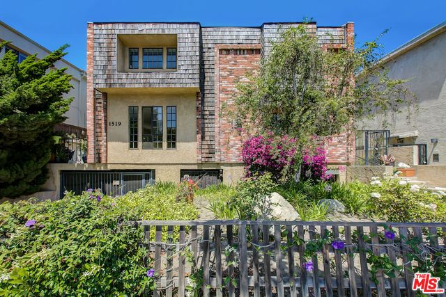 a view of a house with a yard and potted plants