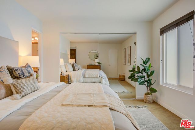 a bedroom with bed and a potted plant