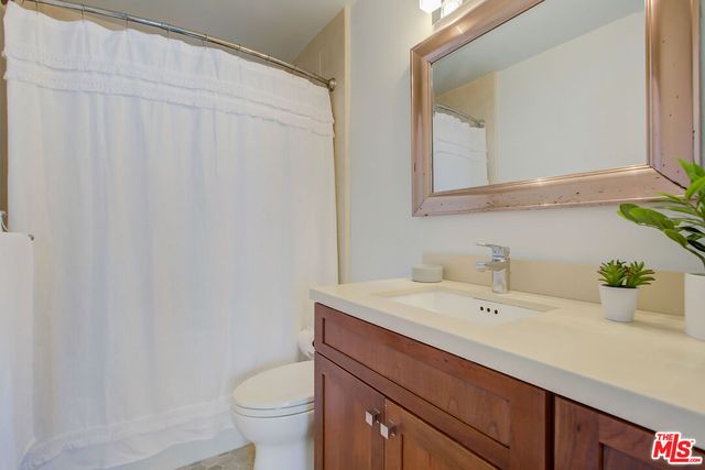 a bathroom with a sink a toilet and mirror
