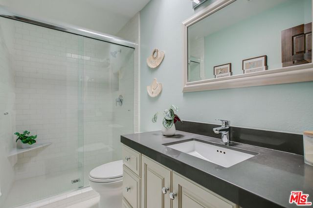 a bathroom with a sink a toilet and a mirror