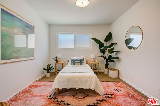 a bedroom with a bed and a potted plant