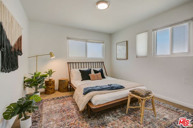 a bedroom with a bed and a potted plant
