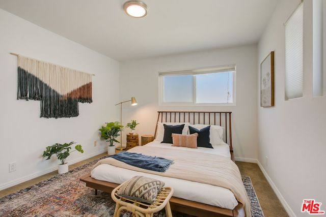 a bedroom with a bed and a potted plant