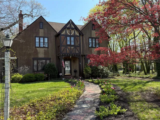 a front view of a house with a yard and trees