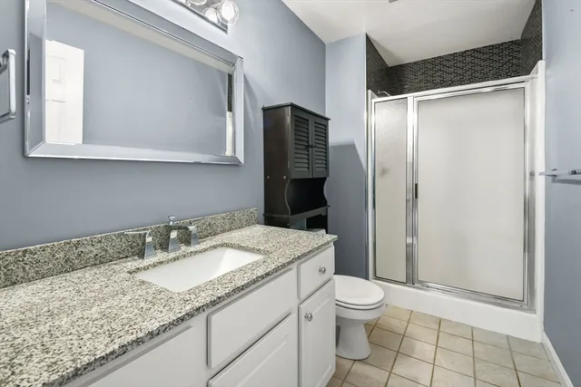 a bathroom with a granite countertop sink toilet and shower