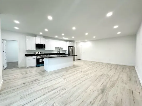 a view of kitchen with granite countertop stainless steel appliances refrigerator oven stove top oven and cabinets