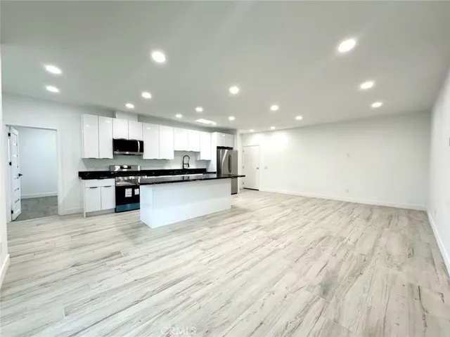 a view of kitchen with granite countertop stainless steel appliances refrigerator oven stove top oven and cabinets