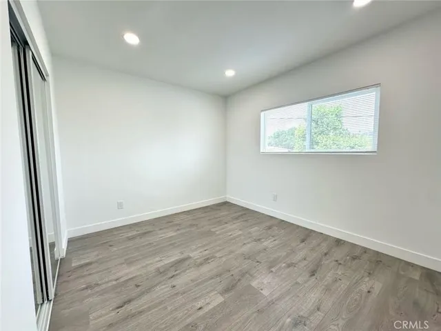 an empty room with wooden floor and window