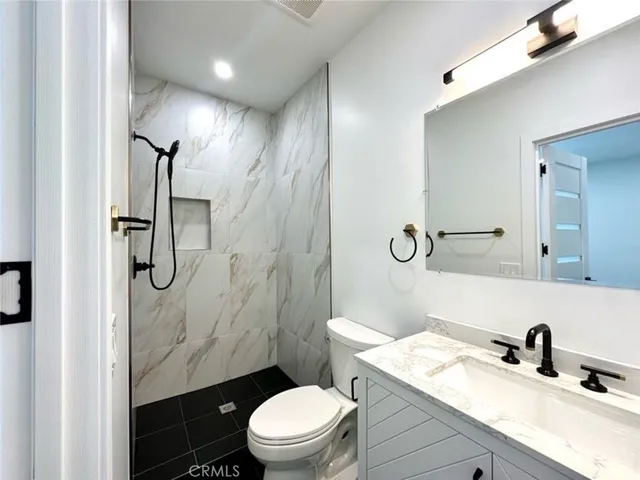 a bathroom with a sink toilet vanity and shower