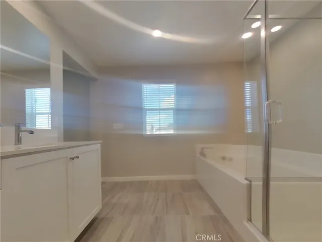 a bathroom with a sink a large mirror and a bathtub