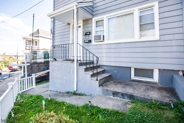 a view of a house with a yard and stairs