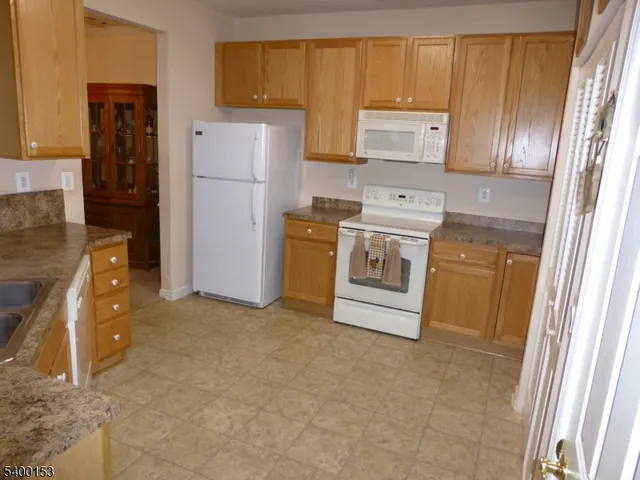 a kitchen with a refrigerator sink stove and cabinets