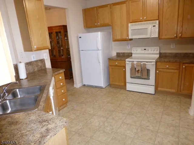 a kitchen with a refrigerator sink stove and cabinets