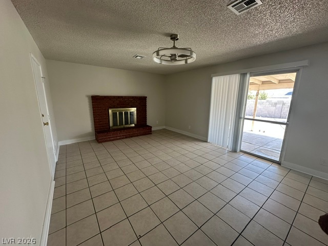 Tiled floors and a brick fireplace anchor this versatile living area opening to the patio.