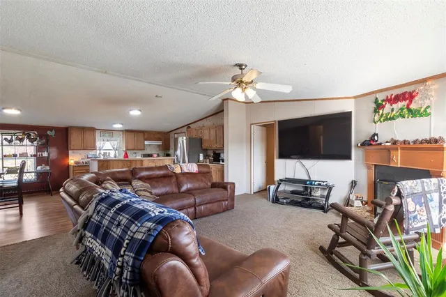 a living room with furniture a flat screen tv and kitchen view