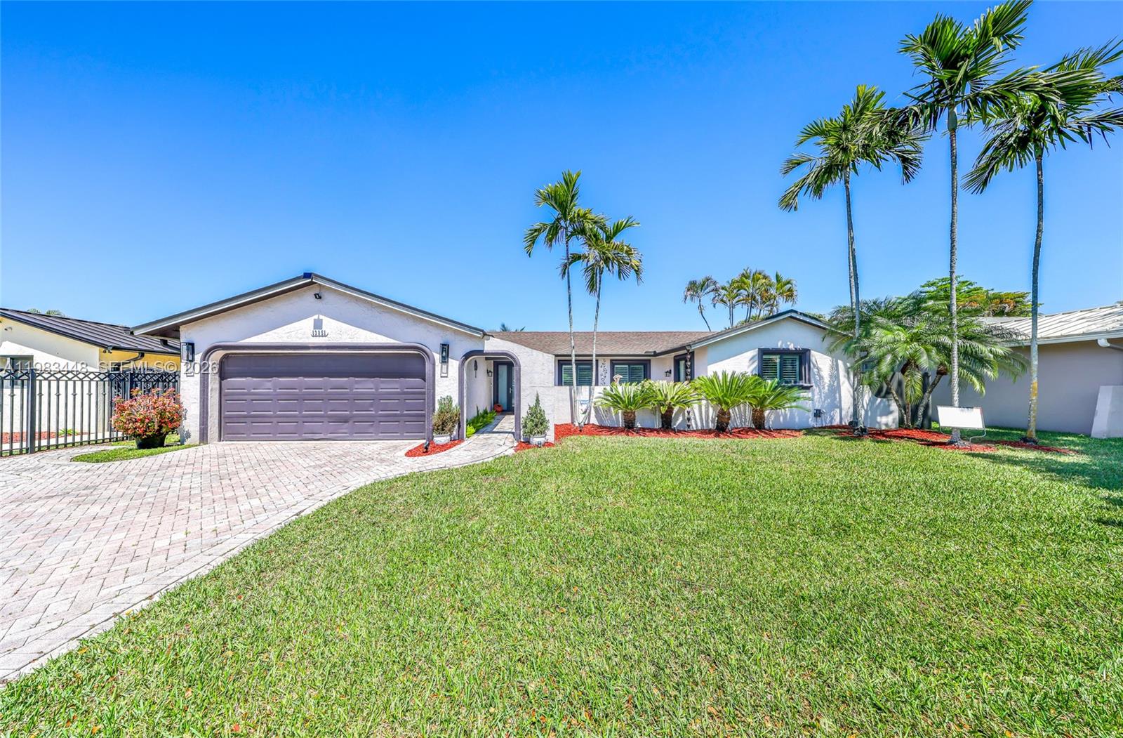 a view of a house with a yard and palm trees