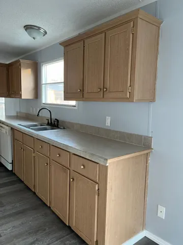 a kitchen with a sink cabinets and a window