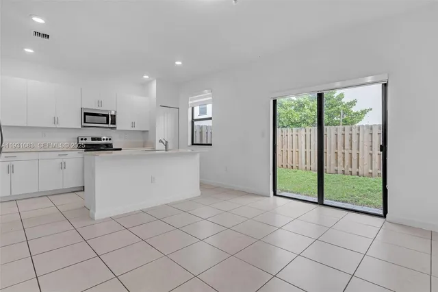 a kitchen with white cabinets a sink and a stove top oven
