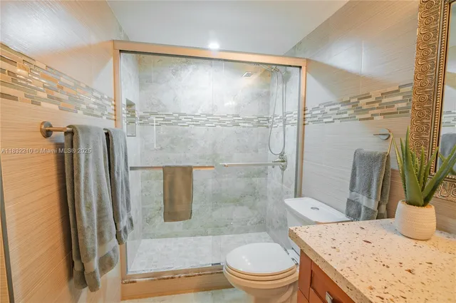 a bathroom with a granite countertop sink toilet and shower