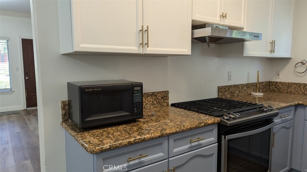 255 North Michigan Avenue, Unit 4 Pasadena, CA 91106 - Photo 8 of 39 a kitchen with granite countertop a stove and a white cabinets
