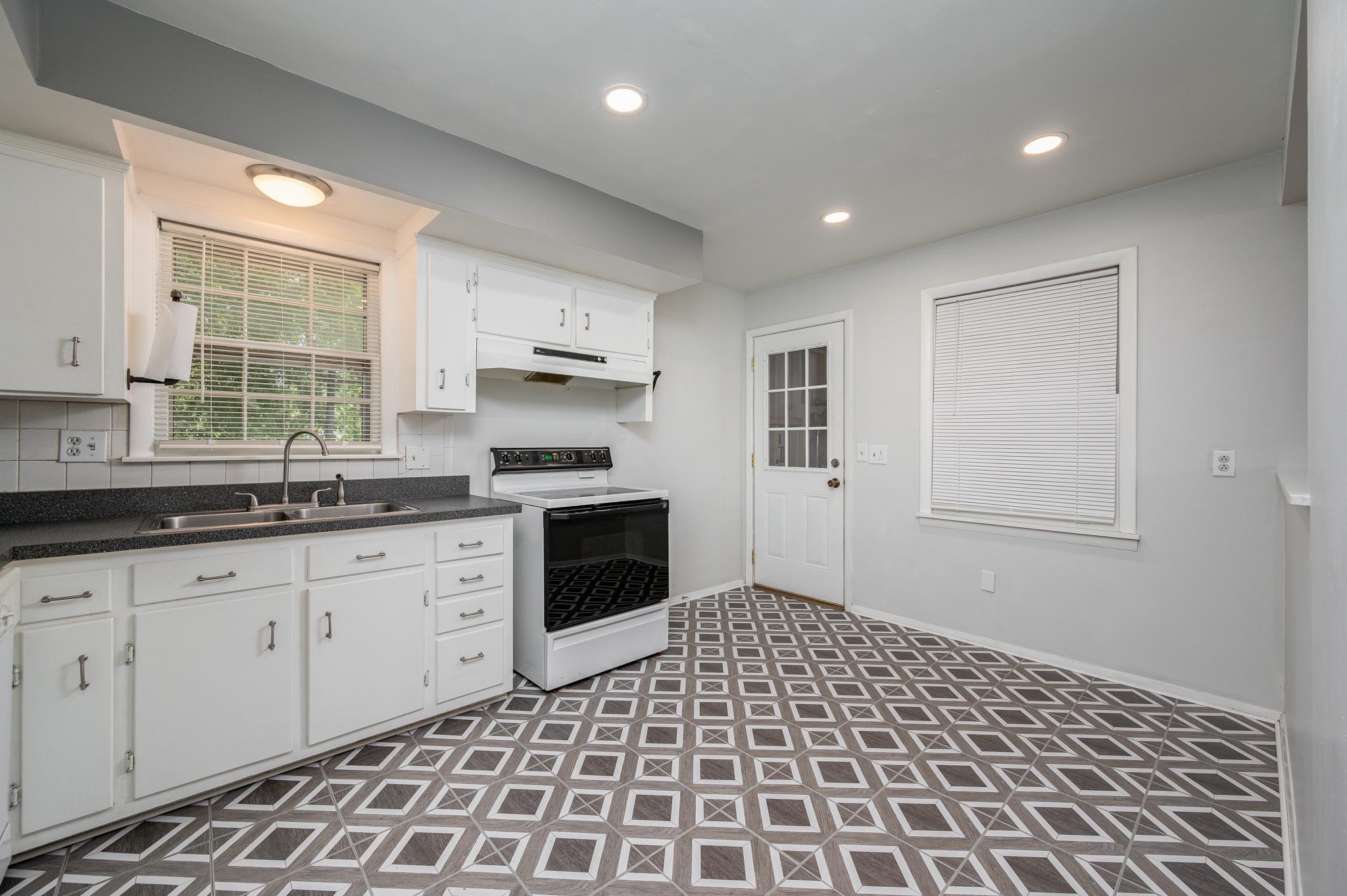 311 Santa Rosa Drive Old Hickory, TN 37138 - Photo 7 of 19 a kitchen with granite countertop a stove a sink a refrigerator a window and cabinets