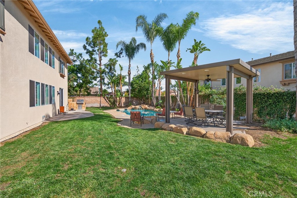 11552 Brookrun Court Riverside, CA 92505 - Photo 44 of 71 a view of a patio with table and chairs potted plants and palm trees