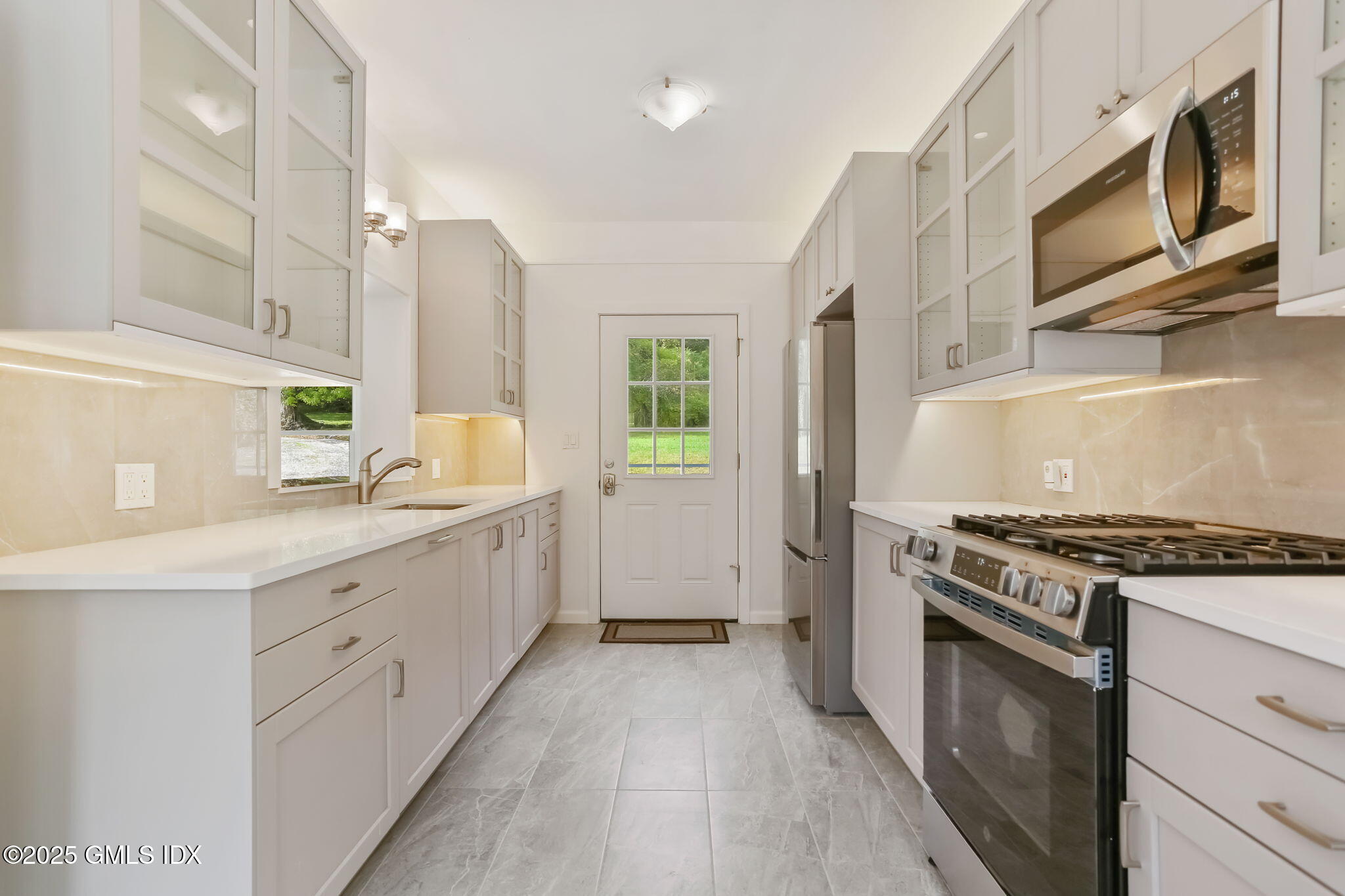 527 Stanwich Road, Unit COTTAGE Greenwich, CT 06831 - Photo 2 of 18 a kitchen with stainless steel appliances granite countertop a stove a sink and a refrigerator