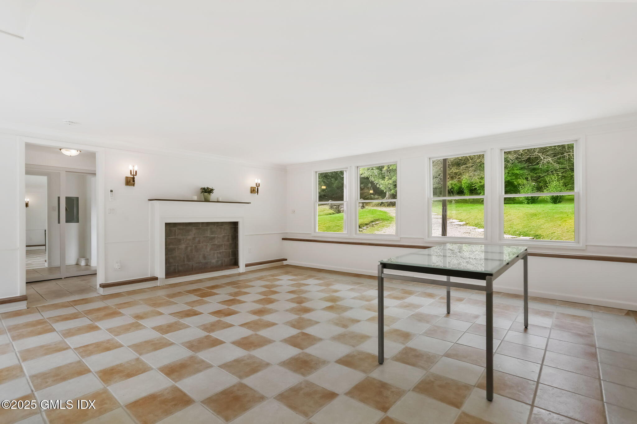 527 Stanwich Road, Unit COTTAGE Greenwich, CT 06831 - Photo 5 of 18 an empty room with windows and a fireplace