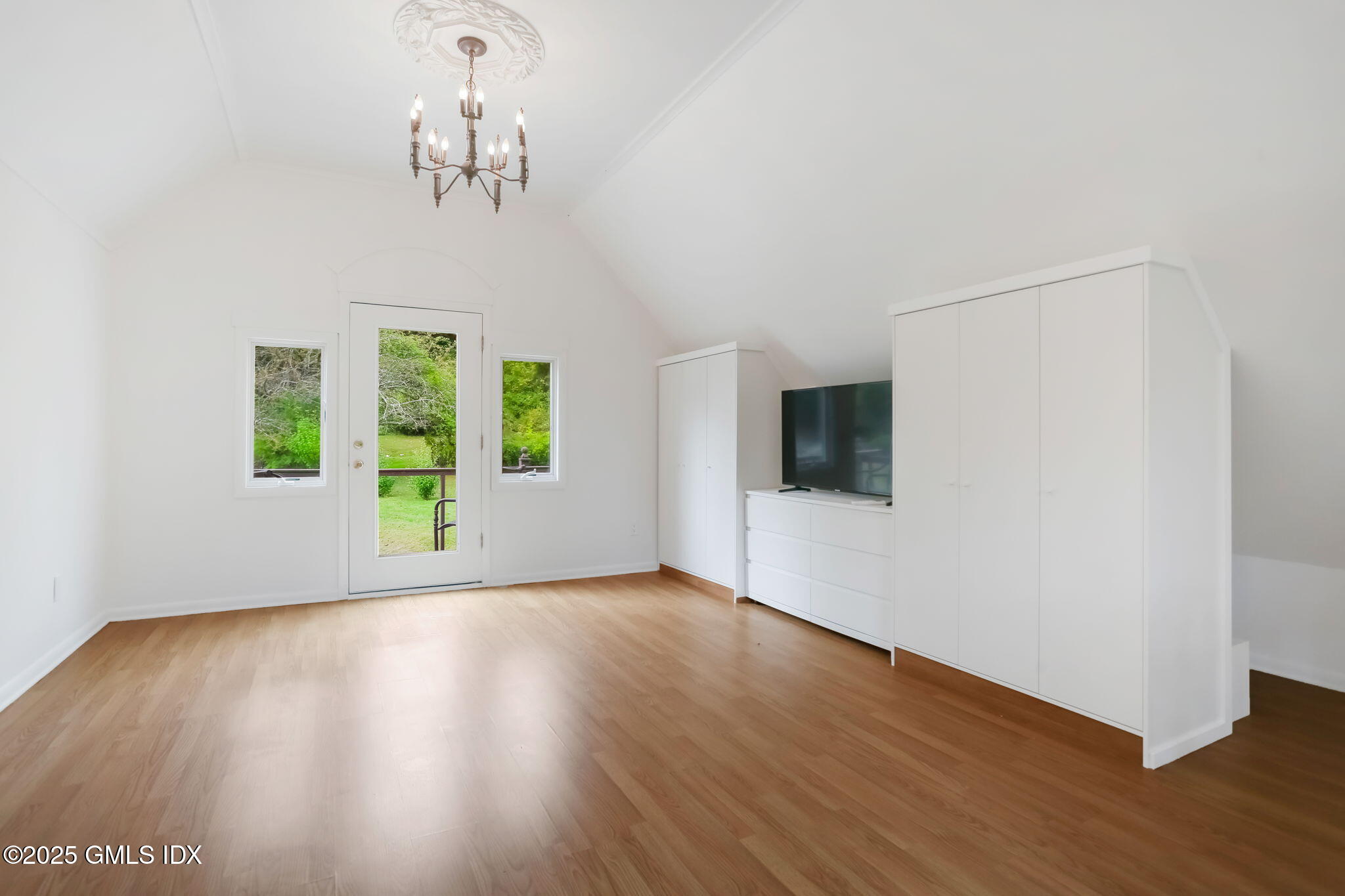 527 Stanwich Road, Unit COTTAGE Greenwich, CT 06831 - Photo 8 of 18 a view of an empty room with wooden floor and a window