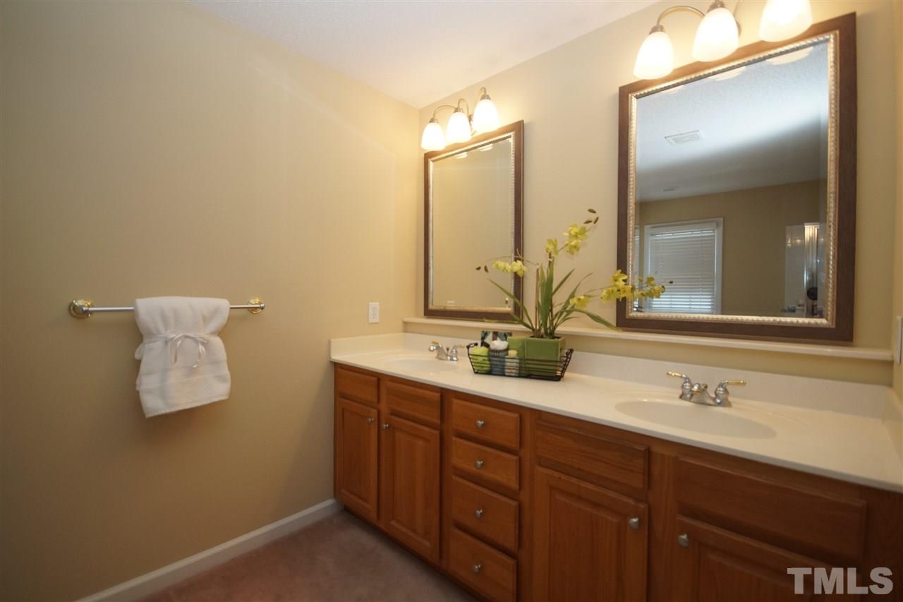 7908 Broad Street Raleigh, NC 27613 - Photo 15 of 24 a bathroom with a double vanity sink and mirror