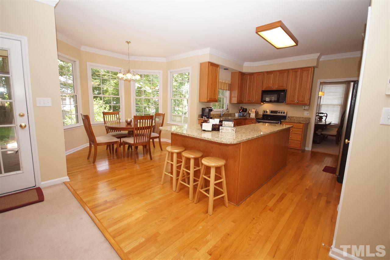 7908 Broad Street Raleigh, NC 27613 - Photo 7 of 24 a view of a dining room with furniture a chandelier and wooden floor