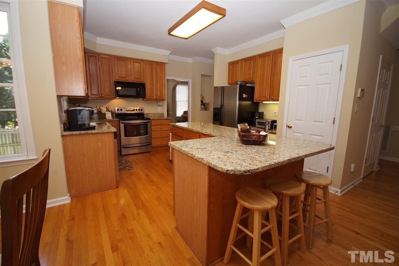7908 Broad Street Raleigh, NC 27613 - Photo 8 of 24 a kitchen with granite countertop kitchen island stainless steel appliances a stove refrigerator sink microwave and cabinets