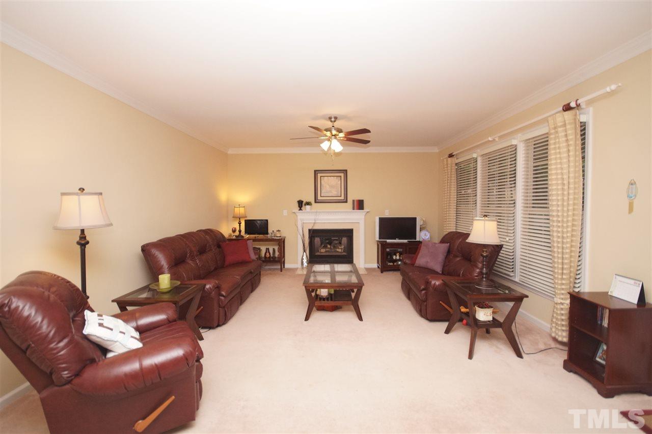 7908 Broad Street Raleigh, NC 27613 - Photo 9 of 24 a living room with furniture a fireplace and a flat screen tv