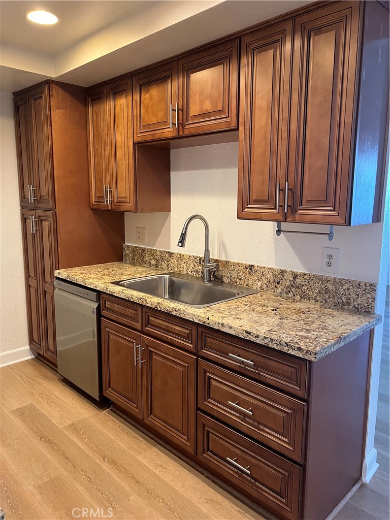 25611 Quail Run, Unit 100 Dana Point, CA 92629 - Photo 6 of 13 a kitchen with granite countertop wooden cabinets a sink and dishwasher