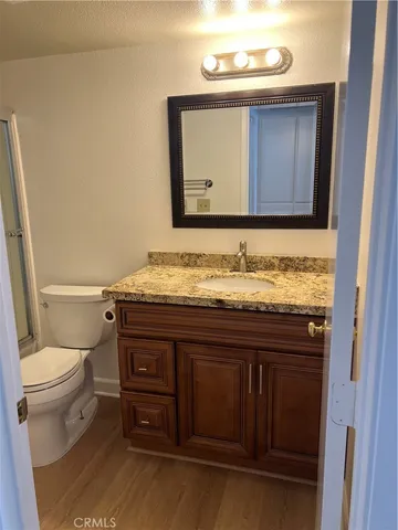 a bathroom with a granite countertop toilet sink and mirror