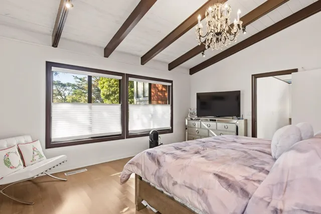 a bedroom with a large bed and a flat tv screen