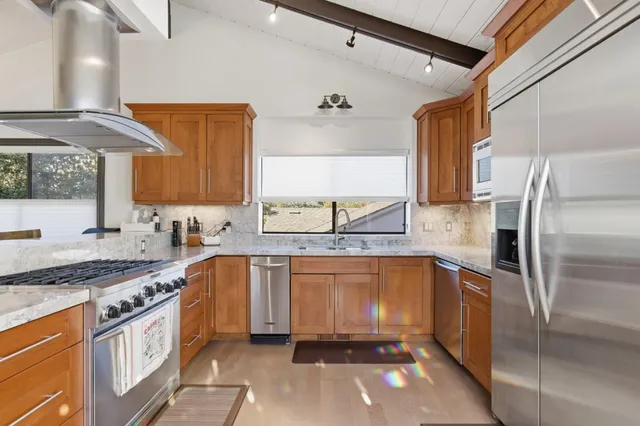 a kitchen with stainless steel appliances granite countertop a sink stove and refrigerator