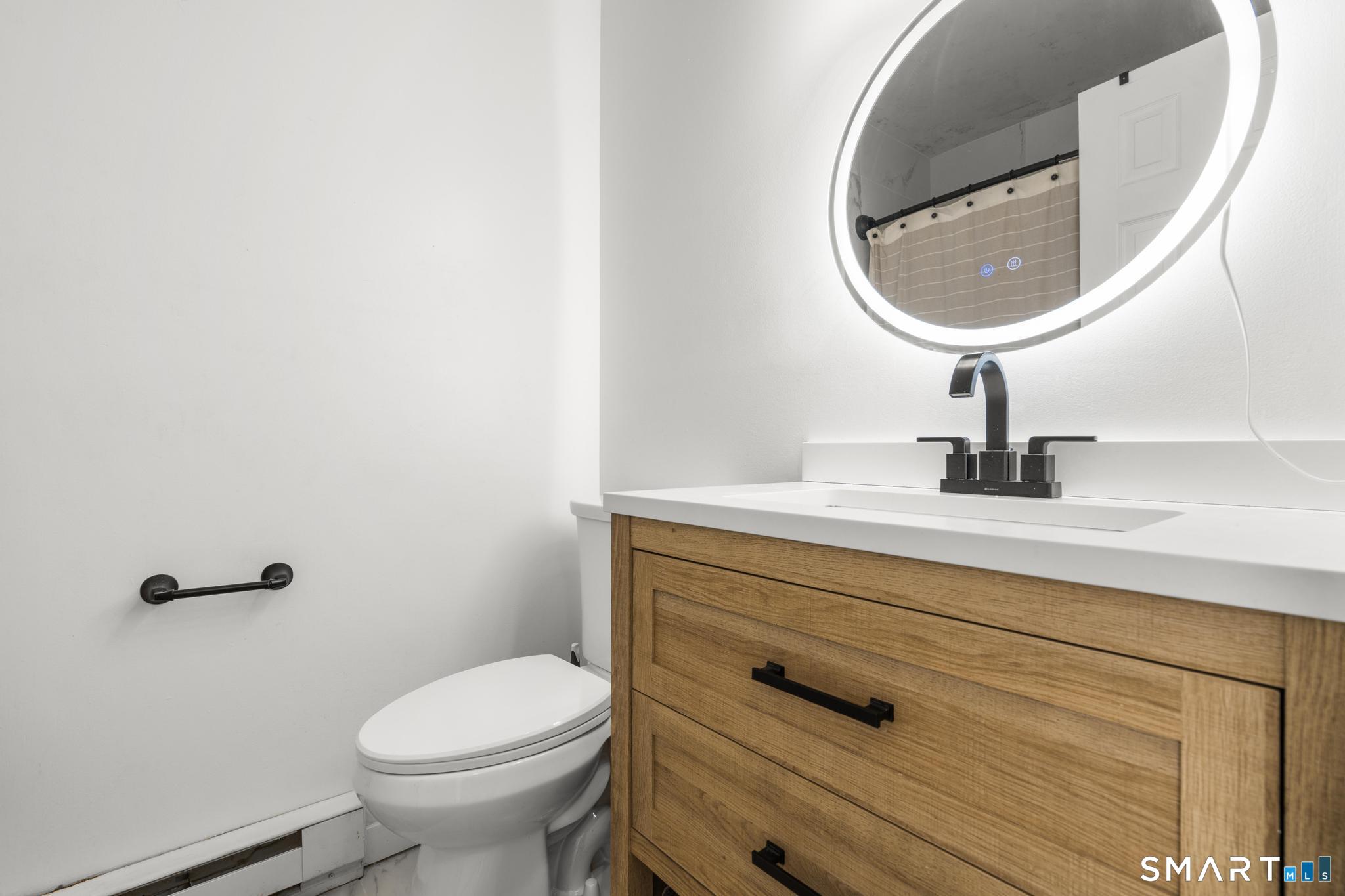 84 Taylor Avenue, Unit 1 Norwalk, CT 06854 - Photo 20 of 40 a bathroom with a sink mirror and toilet