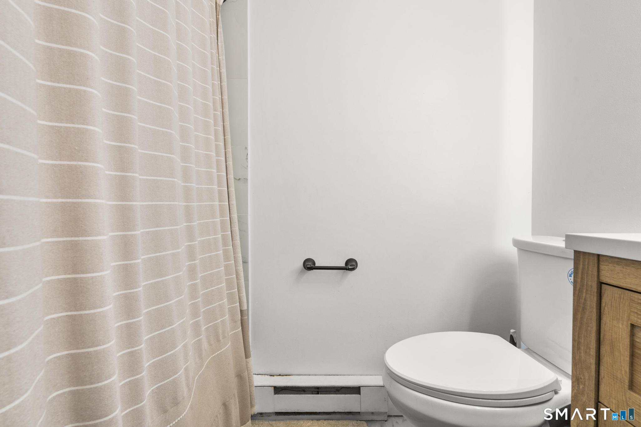 84 Taylor Avenue, Unit 1 Norwalk, CT 06854 - Photo 21 of 40 a white toilet sitting next to a shower curtain