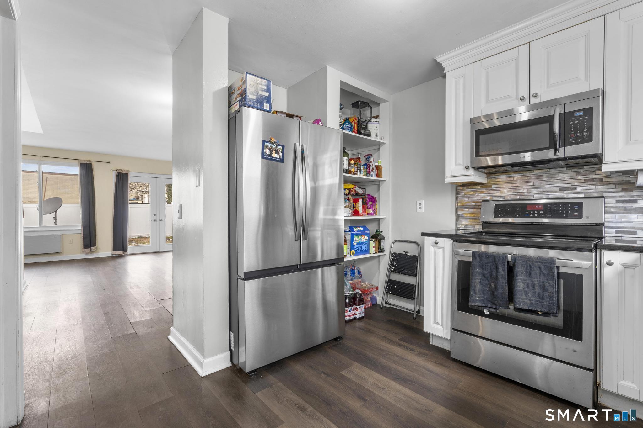 84 Taylor Avenue, Unit 1 Norwalk, CT 06854 - Photo 10 of 40 a kitchen with stainless steel appliances a stove a microwave and a refrigerator